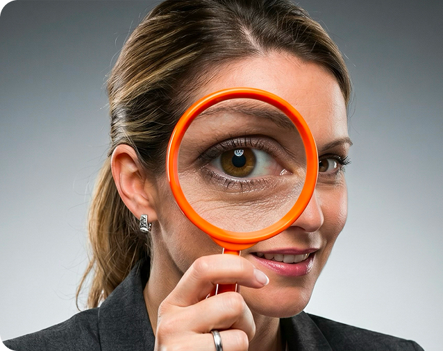 Woman looking through an orange magnifying glass
